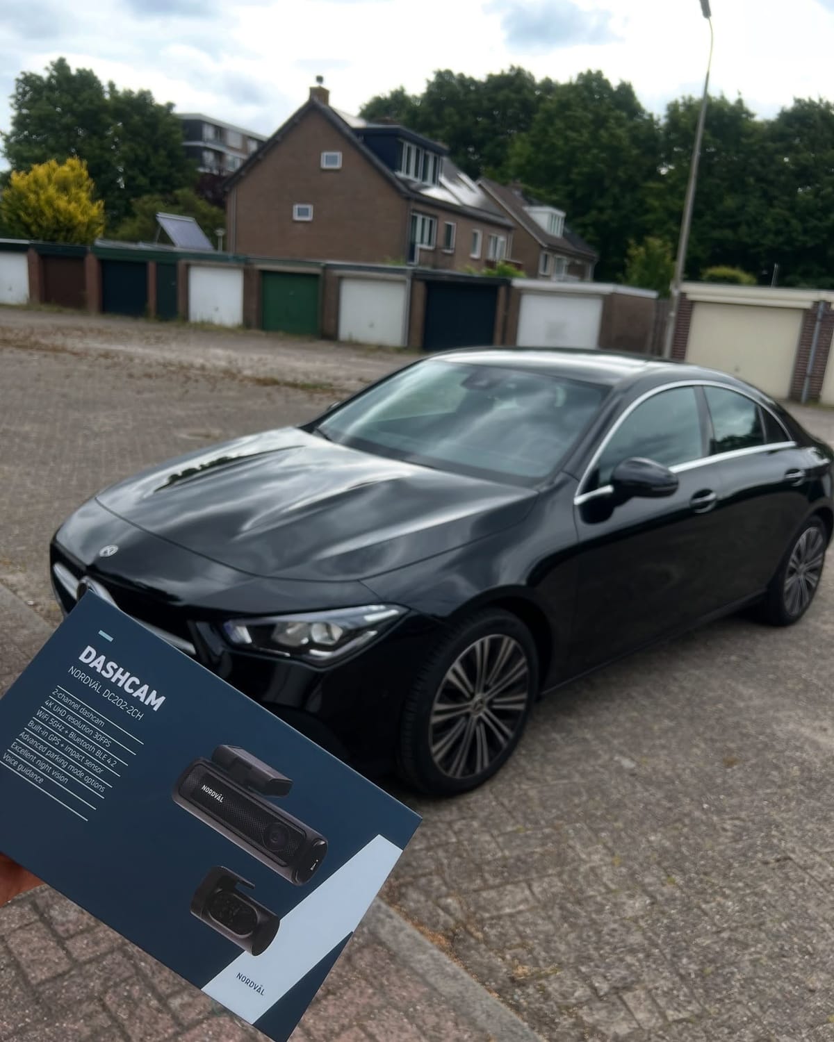Zwarte Mercedes CLA, met de doos van de nieuwe dashcam op de voorgrond